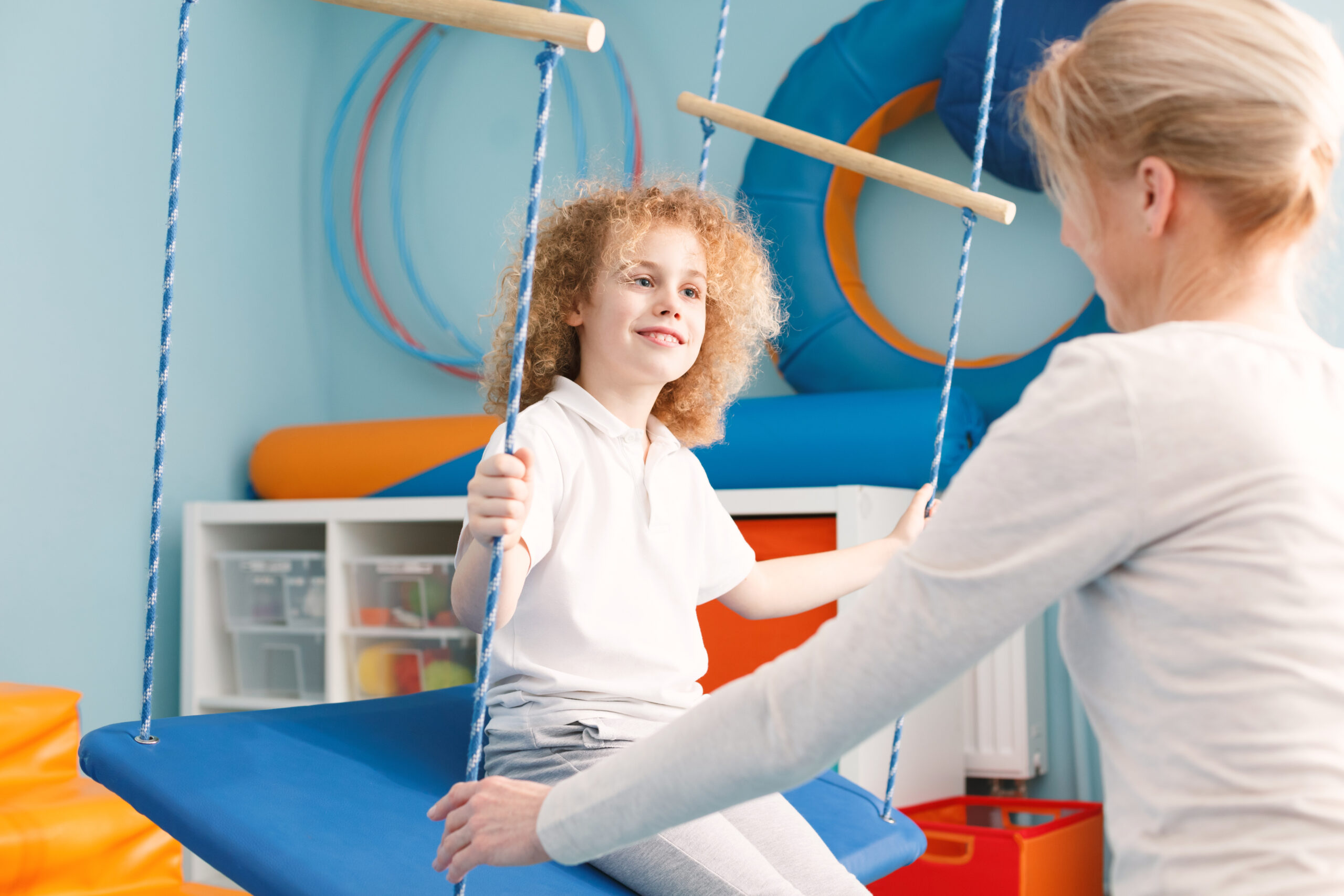 Physiotherapist,And,Child,Sitting,On,Swing,For,Vestibular,Therapy